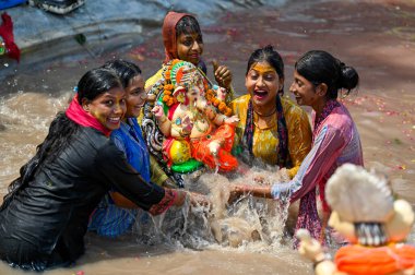 NEW DELHI INDIA SEPTEMBER 17 Eylül 2024 Dindar biri, 17 Eylül 2024 tarihinde Geeta Kolonisi 'nde Ganesh Chaturthi Festivali' nin son gününde Delhi Hükümeti tarafından oluşturulan Ganesh 'in bir heykelini suya batırır.