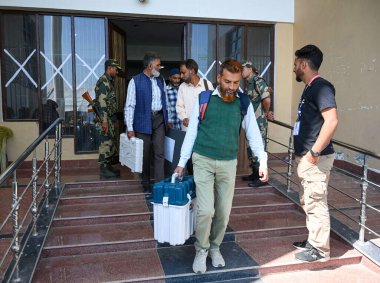 SRINAGAR, INDIA SEPTEMBER 17, 2024 Polling officials carry their Electronic Voting Machines EVM as they leave for their respective polling station ahead of the first phase of Assembly election on September 17, 2024 in Pulwama  clipart