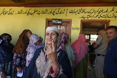 SRINAGARINDIA SEPTEMBER 18 2024 A woman shows her ink-stained finger after casting vote at a polling station during the first phase of assembly elections on September 18 2024 in Kulgam South of Srinagar India. Jammu and Kashmir is witnessing first as clipart