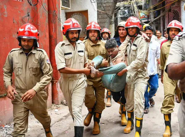 stock image NEW DELHIINDIA SEPTEMBER 18 2024 Fire personnel rescue a person from the collapsed building at Bapa Nagar in Karol Bagh area in the morning on September 18 2024 in New Delhi India. Four people died and 14 others sustained injuries when a five-storey 