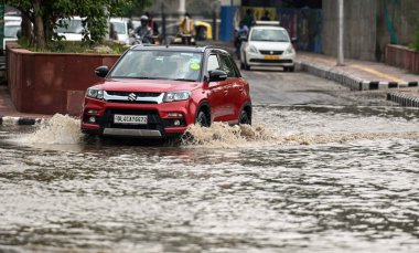 NEW DELHI INDIA JULY 10 2023 Commuters moves through a water logged street after heavy rains lashes out the city at Pragati maiden ring road on July 10 2023 in New Delhi India Several parts of northwest India witnessed a heavy spell of rain breaking  clipart