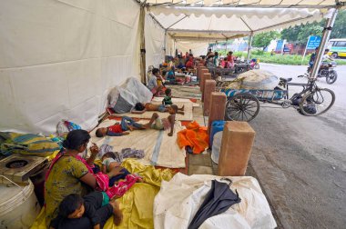 NEW DELHI INDIA JULY 11 2023 People shelter near Iron Pul after relocating from low lying areas near the Yamuna River after it overflowed due to monsoon rains on July 11 2023 in New Delhi India Photo by Sanjeev Verma Hindustan Times clipart