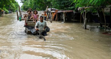 NEW DELHI INDIA 12 HAZİRAN 2023 Yamuna nehri etrafındaki alçak yerlerde yaşayan insanlar, 12 Temmuz 2023 'te Yeni Delhi Hindistan' da, Raj K Raj Hindusta 'nın çektiği, Mayur Vihar nehri kıyısında daha güvenli bir yere taşınırken, taşan sel sularında yüzüyorlar.
