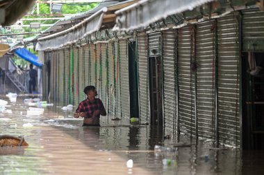 NEW DELHI INDIA 12 Temmuz 2023 'te ISBT yakınlarındaki Manastır pazarında 12 Temmuz 2023' te Hathni Kund yaylım ateşinden sonra Yamuna nehrinin su seviyesi yükselirken, dükkan sahipleri su altındaki dükkanlardan eşyalarını taşır.