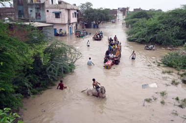 NEW DELHI INDIA 12 Temmuz 2023 Yamuna nehrinin su seviyesi Hathni Kund barajından 12 Temmuz 2023 'te Eski Garhi Mendu Köyü' nde sağanak yağış nedeniyle yükselen su seviyesi nedeniyle sel altındaki evlerden eşyalarını taşır.