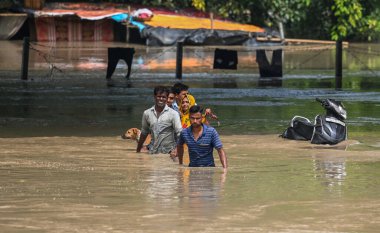 NEW DELHI INDIA 13 HAZİRAN 2023 Yamuna nehri etrafındaki alçak yerlerde yaşayan insanlar, kabaran nehrin taşkın sularından geçerek Mayur Vihar Tarafı yakınlarında daha güvenli bir yere taşınırlar 13 Temmuz 2023 'te Yeni Delhi Hindistan' da Raj K Hindustan Tim tarafından çekilmiştir.