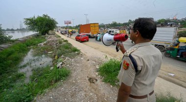 Yeni DELHI INDIA 13 Temmuz 2023 Delhi Polis Memuru, 13 Temmuz 2023 tarihinde Raj 'ın Yeni Delhi Hindistan fotoğrafında Yamuna Nehri' nin su seviyesi yükselirken Yamuna sel ovalarında kalan yerel sakinlere duyuru yaptı. 