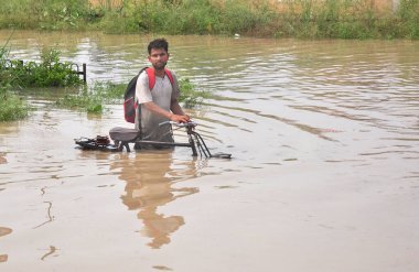 GHAZIABAD INDIA 15 Temmuz 2023 Tronica City ve çevresinde yollar ve lokaller sular altında kaldı ve insanlar daha güvenli yerlere taşınmak ya da 15 Temmuz 'da günlük ihtiyaçlar için ev eşyaları almak için derin sularda yürümeye çalışıyor