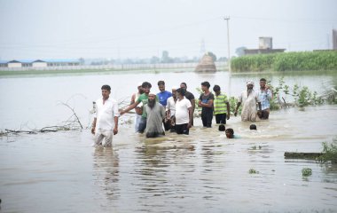 GHAZIABAD INDIA 15 Temmuz 2023 Gaziabad yüzlerce selden etkilenen vatandaş, 15 Temmuz 2023 'te Gaziabad Loni' deki Yamuna nehrinden gelen sel suları nedeniyle evleri ve köyleri sular altında kalırken Alipur seti üzerinde duruyorlar. 