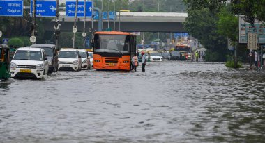 NEW DELHI INDIA JULY 15 2023 Commuters make their way through the waterlogged ITO Vikas Marg due to the rise in water levels of Yamuna River following heavy monsoon rains on July 15 2023 in New Delhi India The water level of the river has been rising clipart