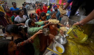 NEW DELHI INDIA 15 Temmuz 2023 Gönüllüler, Mayur Vihar bölgesindeki Yamuna nehrinin su seviyesinde 15 Temmuz 2023 'te yükselen artışın ardından sel baskını için gıda ve diğer yardım materyalleri dağıtıyorlar.