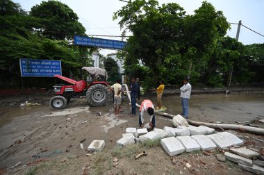 NEW DELHI INDIA JULY 15 2023 PWD along with MCD workers seen trying to clean the silt remained on Ring road from Yamuna River at Chandgiram Akhara on July 15 2023 in New Delhi India The water level of the river has been rising since Wednesday after i clipart