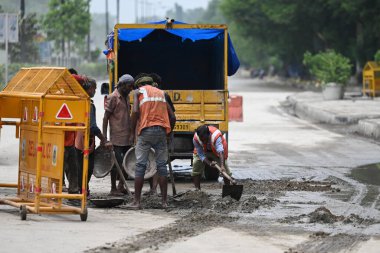 NEW DELHI INDIA JULY 15 2023 PWD along with MCD workers seen trying to clean the silt remained on Ring road from Yamuna River at Chandgiram Akhara on July 15 2023 in New Delhi India The water level of the river has been rising since Wednesday after i clipart