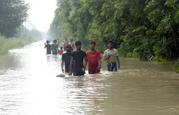 stock image GHAZIABAD INDIA JULY 15 2023 The roads and localities in and around the Tronica City remained submerged in water and people are trying to wade through deep water in order to move to safer places or to get households items for daily needs on July 15 2