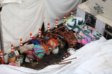 NEW DELHI INDIA 16 HAZİRAN 2023 Sel etkilenen insanlar sabahın erken saatlerinde Mayur Vihar 'ın karşısında 16 Temmuz 2023 tarihinde Yeni Delhi Hindistan' da bir yol kenarı çadırında sivrisinek ağı altında uyuyorlar. Nehrin su seviyesi Çarşamba gününden beri yükseliyor.