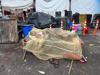 NEW DELHI INDIA JULY 16 2023 Flood affected people are sleeping under mosquito net during early morning hours at a roadside tent opposite Mayur Vihar on July 16 2023 in New Delhi India The water level of the river has been rising since Wednesday afte clipart