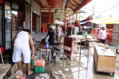 16 Temmuz 2023 'te Hanuman Mandir Jamuna Çarşısı' nın yakınlarındaki sel suları çekilirken, Yeni Delhi 'de 16 Temmuz 2023' te dükkanı temizleyen işçiler ve işçiler yeni Delhi 'de su seviyesi nefes aldıktan sonra Çarşamba gününden beri yükseliyor.