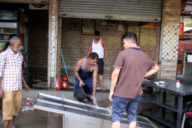 NEW DELHI INDIA JULY 16 2023 As the floodwater recede near Hanuman Mandir Jamuna Bazar shop owners and workers cleaning the shop to restart on July 16 2023 in New Delhi India The water level of the river has been rising since Wednesday after it breac clipart