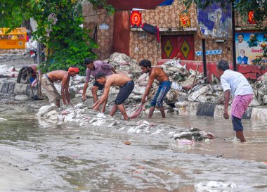 NEW DELHI INDIA 16 Temmuz 2023 İnsanlar 16 Temmuz 2023 sabahı Yeni Delhi Hindistan 'da Yamuna Çarşısı yakınlarındaki sel sularını kontrol etmek için temiz kum torbaları koydu.