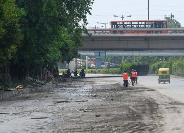 NEW DELHI INDIA 16 Temmuz 2023 İşçiler, 16 Temmuz 2023 'te Yeni Delhi Hindistan' da sular çekildikten sonra ISBT yakınlarındaki Manastır Pazarı 'nın önündeki yolu temizledi.