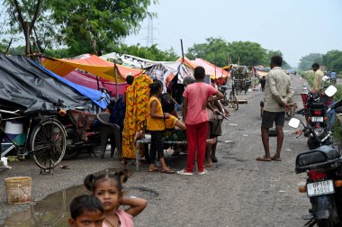 18 Temmuz 2023 'te Noida Hindistan' da Sunil Ghosh Hindus tarafından çekilen fotoğraf ile Yamuna Nehri 'nin 128. Bölgesindeki Yamuna Nehri yakınlarındaki yerleşim yerlerinde yaşayan NOIDA 18 Temmuz 2023' te evleri sular altında kaldıktan sonra geçici çadırlara yerleştirildi.