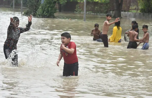 NEW DELHI INDIA 15 HAZİRAN 2023 Shantivan yakınlarındaki sel sularında eğlenen insanlar 15 Temmuz 2023 'te Yeni Delhi Hindistan' da akan şiş Yamuna nehri yakınlarındaki bölgeleri sular altında bırakırken nehrin su seviyesi Çarşamba gününden beri yükseliyor.