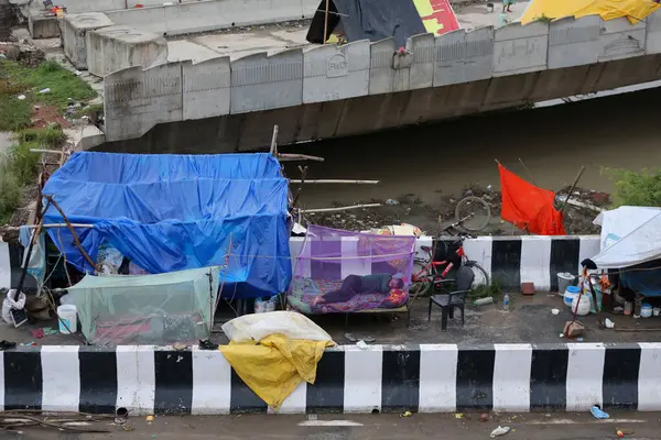 NEW DELHI INDIA 16 HAZİRAN 2023 Sel etkilenen insanlar sabahın erken saatlerinde Mayur Vihar 'ın karşısında 16 Temmuz 2023 tarihinde Yeni Delhi Hindistan' da bir yol kenarı çadırında sivrisinek ağı altında uyuyorlar. Nehrin su seviyesi Çarşamba gününden beri yükseliyor.