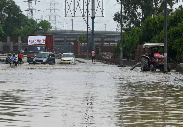 NEW DELHI INDIA 16 Temmuz 2023 Traktörler Nigambodh Ghat yakınlarındaki halka yolunda 16 Temmuz 2023 sabahı Yeni Delhi Hindistan 'da sel sularını çekmek için kullanılır.