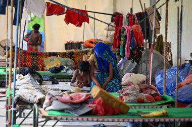Yamuna Nehri 'nin 23 Temmuz 2023' te Eski Demir Köprü 'de muson yağmurları nedeniyle kabarması nedeniyle Sanchit Khanna Hindustan Times tarafından çekilen Yeni Delhi' de 23 Temmuz 2023 'de insanlar evlerini boşalttıktan sonra derme çatma bir çadırda yaşıyorlar.