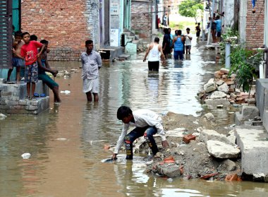 GREATER NOIDA INDIA 24 HAZİRAN 24 HAZİRAN 2023 Hindon nehri etrafındaki alçak yerlerde yaşayan insanlar, kabaran nehrin taşkın sularından geçerek Purana Haibatpur köyünde 24 Haziran 2023 'te Büyük Noida Hindistan' da Sunil Gh tarafından çekilmiştir.
