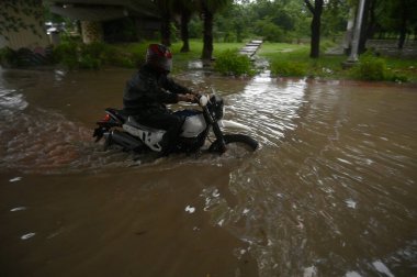 NOIDA INDIA JULY 26 2023 Commuters pass through a heavily waterlogged stretch of road at Sector 44 on July 26 2023 in Noida India The residents of Delhi NCR witnessed heavy rainfall Commuters faced problems due to waterlogging in several areas The IM clipart