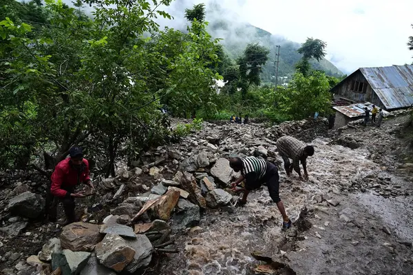 stock image SRINAGAR INDIA JULY 22 2023 People pile rocks and boulders to stop floodwaters from entering their field following flash floods in the Faqir Gujri area on the outskirts of Srinagar on July 22 2023 in Srinagar India Continuous heavy rains have been ba