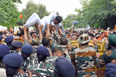 NEW DELHI INDIA AUGUST 17 2023 Security personnel attempt to stop BJP workers during a protest march against the Delhi government over alleged Panic Button Scam on August 17 2023 in New Delhi India The BJP has accused the Delhi Transport Department o clipart