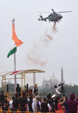 YENİ DELHI INDIA 15 AĞUSTOS 2023 IAF Mi 17V5 helikopter, tarihi Kızıl Kale 'deki 77. Bağımsızlık Günü' nde Kızıl Kale 'nin surlarında Başbakan Narendra Modi tarafından açılan ulusal bayrak olarak çiçek yaprakları yağdırıyor.