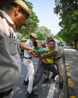 NEW DELHI INDIA OCTOBER 1 2024 Delhi Police officials detains the Members of Tibetan Youth Congress who are protesting against the Cultural Genocide in Tibet by China on 75th Founding Anniversary of their resistance outside Chinese Embassy on October clipart