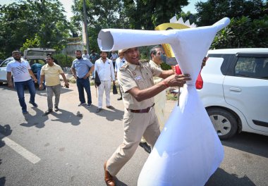 NEW DELHI INDIA OCTOBER 15 2024 Delhi Police officials removes the effigy of Delhi Government as members from Delhi Taxi Tourists Transporters and Tour operators Association protests against the Delhi Transport Department for their various demands at clipart