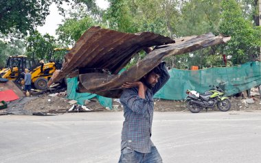 NEW DELHI INDIA HAZİRAN 12023 Vatandaşlar, Pragati Meydanı yakınlarındaki Bhairon Marg 'a yürüttükleri saldırı girişiminin ardından eşyalarını kurtarmaya çalışıyorlar. 