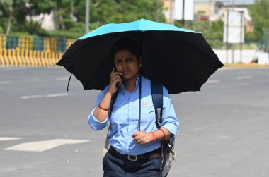 2 Haziran 2023 'te Noida Hindistan' da 38. bölgede onları sıcak yaz gününden korumak için başları örtülü gezenler görülüyor. 