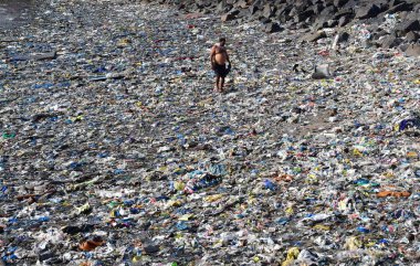 MUMBAI INDIA 5 Haziran 2023 Bir adam 5 Haziran 2023 tarihinde Mumbai Hindistan 'da, Dünya Çevre Günü Colaba' da Badhwar Park yakınlarında tonlarca plastik atık arasında yürür.