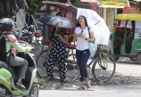 GURUGRAM INDIA 2 Haziran 2023 Bir şemsiye tutan kızlar sıcak bir günde Eski Delhi Yolu 'nda 14 Haziran 2023 tarihinde Hindistan Gurugramı' nda Parveen Kumar Hindustan Times tarafından çekilmiştir.