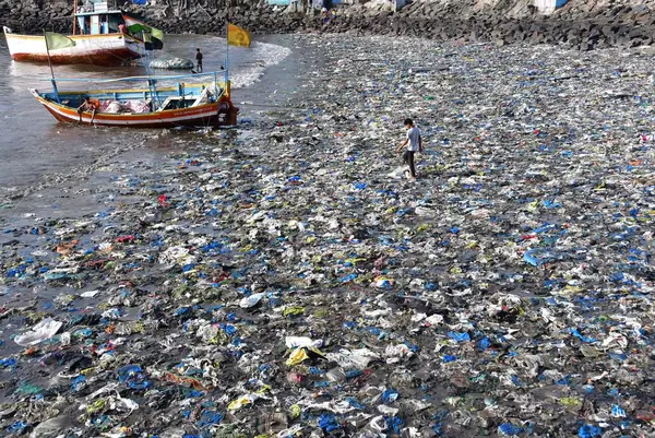 MUMBAI INDIA 5 Haziran 2023 Bir çocuk 5 Haziran 2023 'te Mumbai' de Dünya Çevre Günü Colaba 'da Badhwar Park yakınlarında tonlarca plastik atık arasında yürür. 