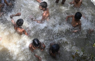 GURUGRAM INDIA 11 Haziran 2023 Çocuklar, 11 Haziran 2023 'te Gurugram Hindistan' da Parveen Kumar Hindustan Times tarafından çekilen Gurugram Fotoğrafı 'nda, 29. bölgedeki sıcak yaz gününde serinlemek için su akıntısının altındaki bir çukurda yıkanırlar.