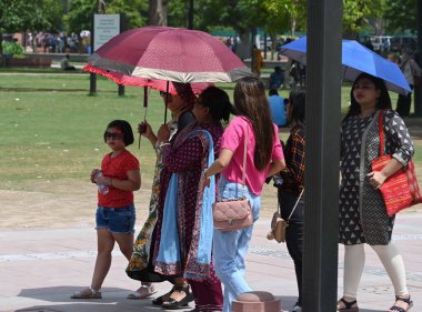 NEW DELHI INDIA HAZİRAN 11 HAZİRAN 2023 Sıcak bir günde Kartvaya Yolu çimlerine bakan şemsiyeli banliyö görevlileri 11 Haziran 2023 'de Yeni Delhi Hindistan' da Vipin Kumar Hindustan Times tarafından çekilmiştir.