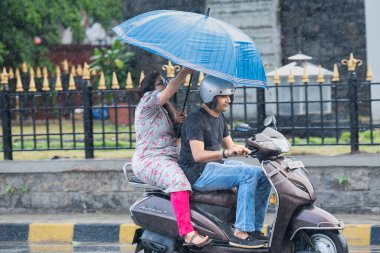 MUMBAI INDIA 11 Haziran 2023 Pillion yolcuları Anshuman Poyrekar Hindustan Times tarafından Mumbai Hindistan 'da 11 Haziran 2023 tarihinde Chhatrapati Shivaji Maharaj Terminalinde aniden yağan yağmurla ilgilenir.