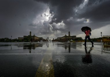 YENİ DELHI INDIA 16 HAZİRAN 2023 Bir adam, yağmurlu bir günde Vijay Chowk 'un üzerinde kara bulutların altında yürür Yeni Delhi' de 16 Haziran 2023 Hindistan Meteoroloji Bölümü, Perşembe günü Delhi NCR 'de şiddetli rüzgarlarla hafif yağmur öngörmüştü.