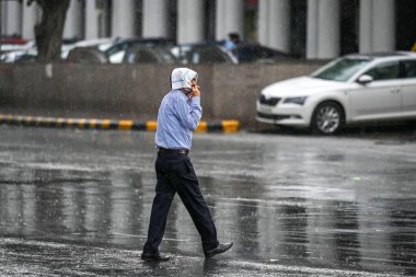 NEW DELHI INDIA JUNE 19 2023 Commuters during sudden rainfall at Connaught Place on June 19 2023 in New Delhi India The city received 5mm of rainfall during the 24 hour period which ended at 8 30am on Monday The minimum temperature settled at 25 5 de clipart