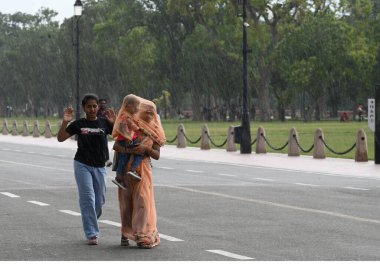 NEW DELHI INDIA JUNE 19 2023 Visitors at the Kartvaya Path in heavy drizzle on June 19 2023 in New Delhi India The city received 5mm of rainfall during the 24 hour period which ended at 8 30am on Monday The minimum temperature settled at 25 5 degrees clipart