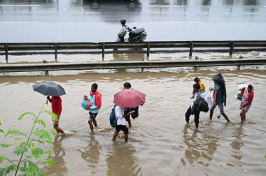 GURUGRAM INDIA JUNE 25 2023 People walk through a waterlogged stretch after heavy rains at National Highway 48 near Narsinghpur village foot over bridge on June 25 2023 in Gurugram India Heavy rainfall accompanied by lightning lashed several parts of clipart