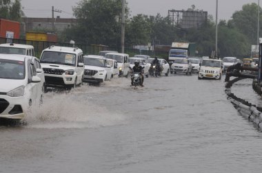 GURUGRAM INDIA JUNE 25 2023 Vehicle drive through a waterlogged stretch after heavy rains at National Highway 48 near Khandsa village on June 25 2023 in Gurugram India Heavy rainfall accompanied by lightning lashed several parts of the national capit clipart