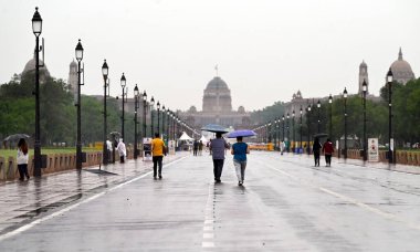 NEW DELHI INDIA 25 HAZİRAN 2023 Ziyaretçiler ve sabah yürüyüşçüleri 25 Haziran 2023 Hindistan Kapısı yakınlarındaki hafif yağmurun keyfini çıkarıyorlar Yeni Delhi Hindistan 'da sağanak yağış ile birlikte ulusal başkent Delhi' nin bazı bölgelerini ve bitişik sanayi bölgelerini yıldırımlar vurdu.